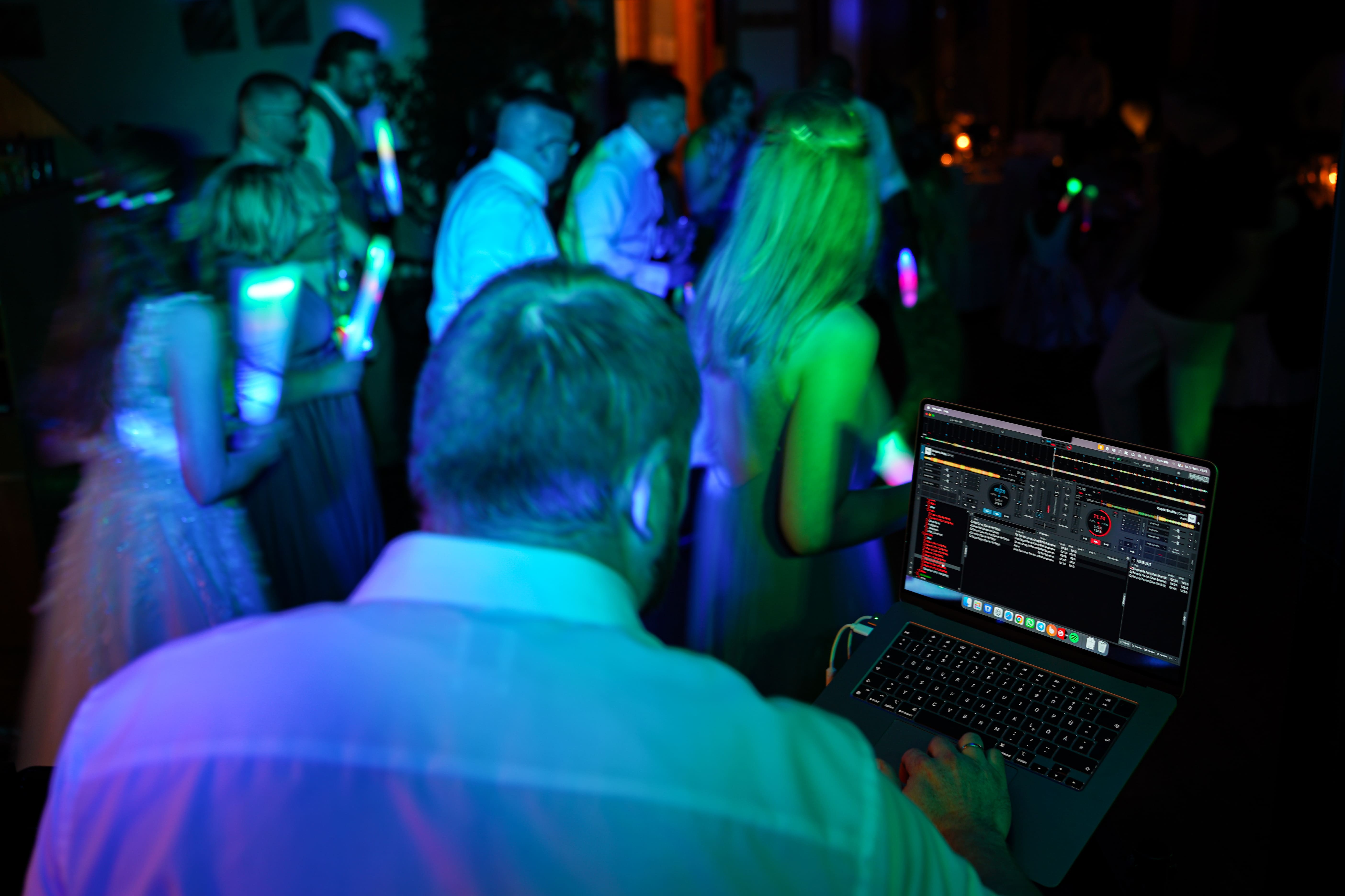 Blick von DJ Tony Lötzke auf eine volle Tanzfläche mit tanzenden Hochzeitsgästen und bunter Lichtshow