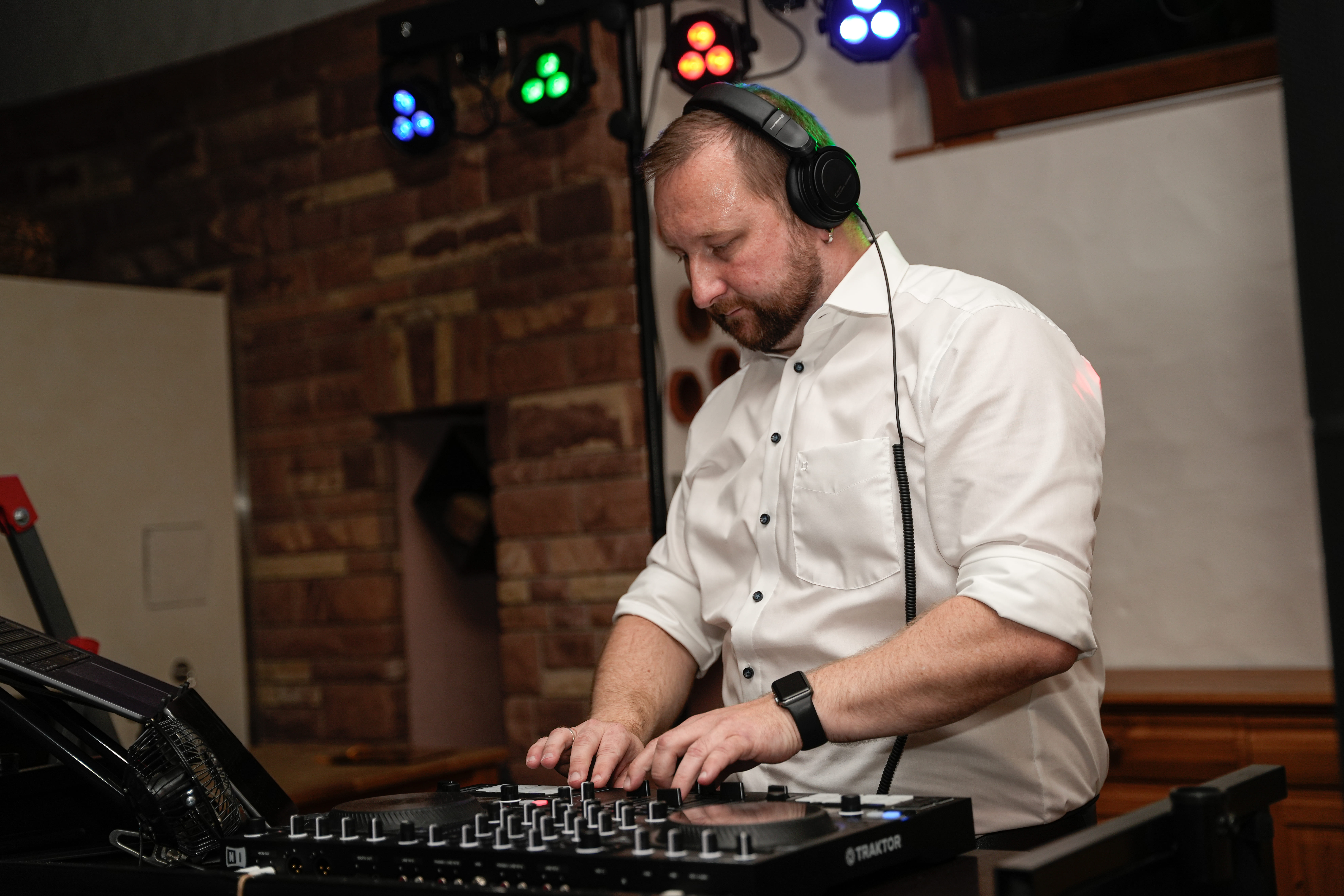 Hochzeits-DJ Tony Lötzke am DJ-Pult mit Kopfhörern und RANE Controller bei einer Hochzeitsfeier